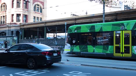 green tram moving along city street