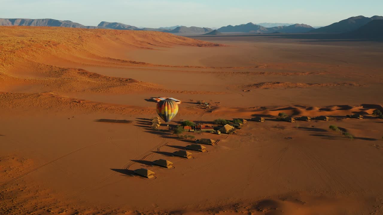 vista aérea de un globo de aire caliente que despega de una cabaña de safari para volar a los turistas sobre el hermoso y pintoresco desierto de namib, namibia