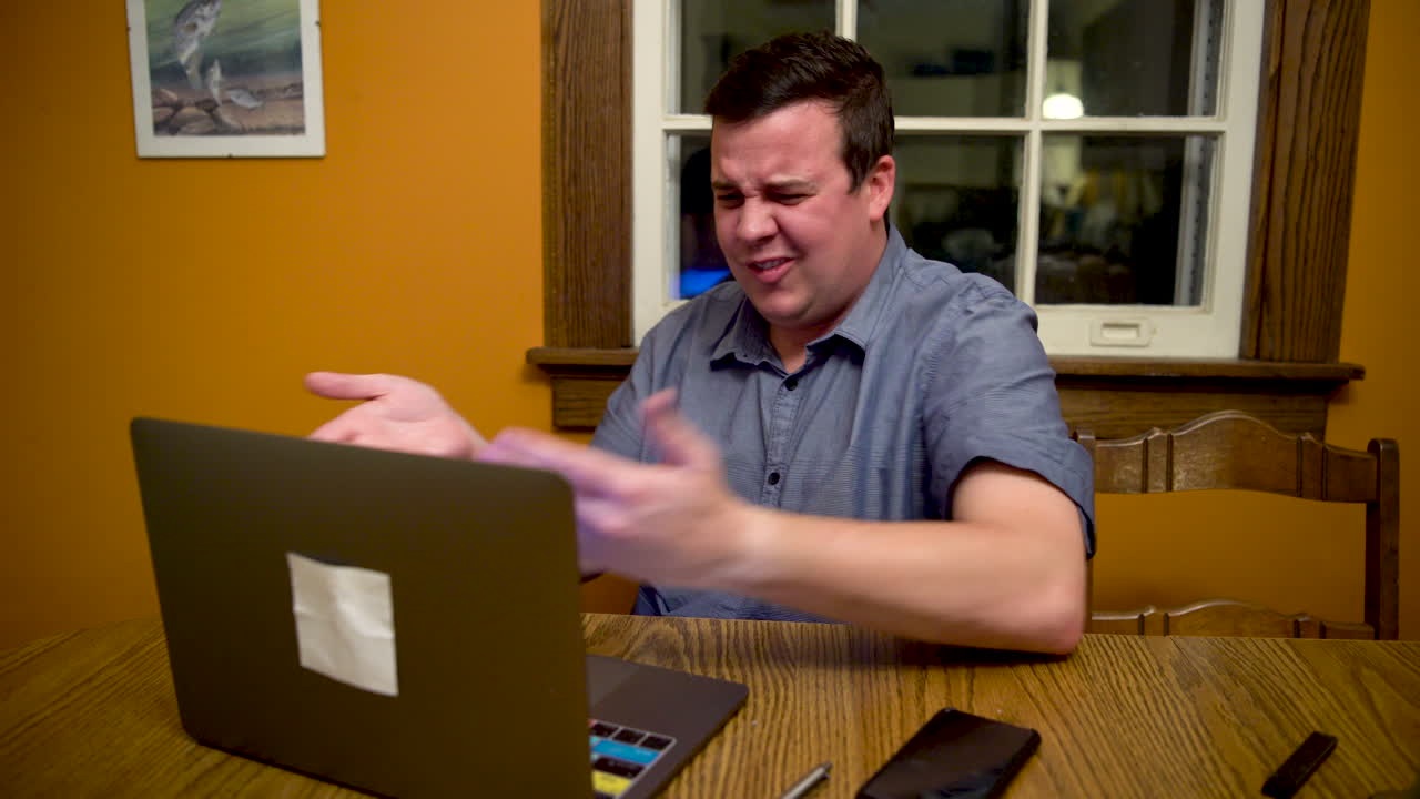 hombre confundido acerca de lo que está viendo en su computadora portátil