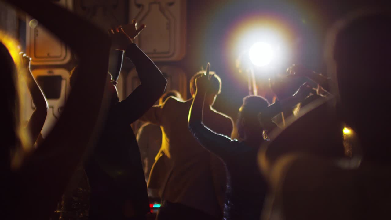 손을 높이 들고 춤을 추는 군중