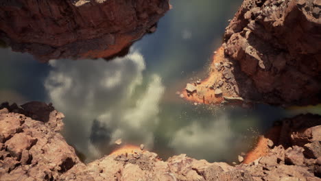 aerial view of a canyon with a pool of water and cloud reflections