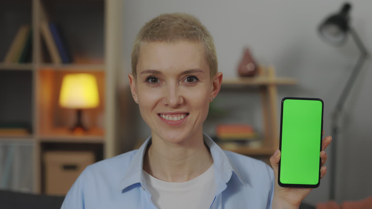 mujer sosteniendo un teléfono inteligente con pantalla verde