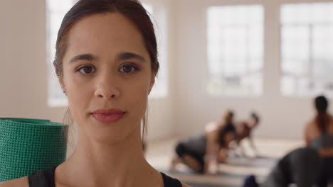 portrait beautiful yoga woman smiling confidently hispanic female enjoying healthy lifestyle with people practicing in fitness studio background