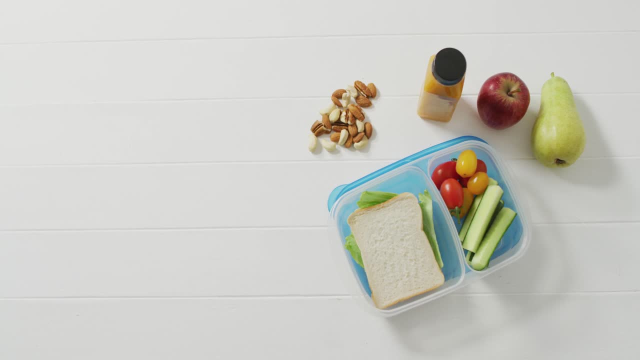 video de la caja de almuerzo con sándwich y bocadillos de verduras saludables con nueces y frutas y espacio de copia
