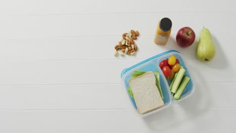 Video-of-lunch-box-with-sandwich-and-healthy-vegetable-snacks-with-nuts-and-fruit-and-copy-space