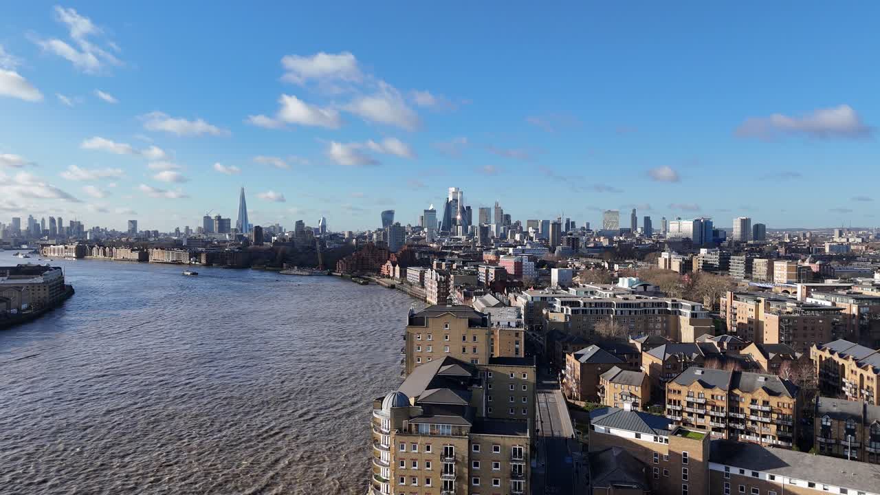 Panning drone aerial Wapping over River Thames city skyline in background