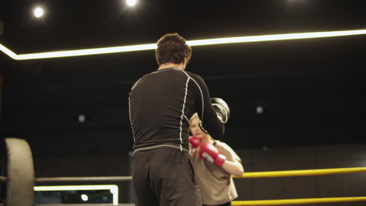 스포츠 클럽에서 코치와 함께 훈련하는 긍정적 인 피트 소녀. 체육관에서 권투하는 스포츠 여성