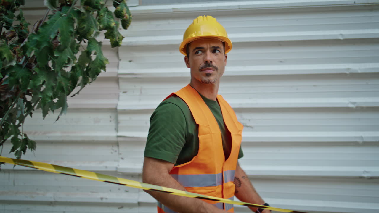 Construction worker attaching stretch at city closeup. Uniform man enclosing