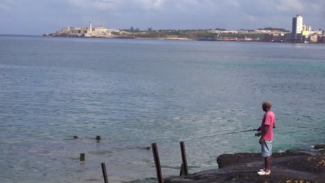 un pescador se encuentra en el paseo marítimo del malecón en la habana cuba 1