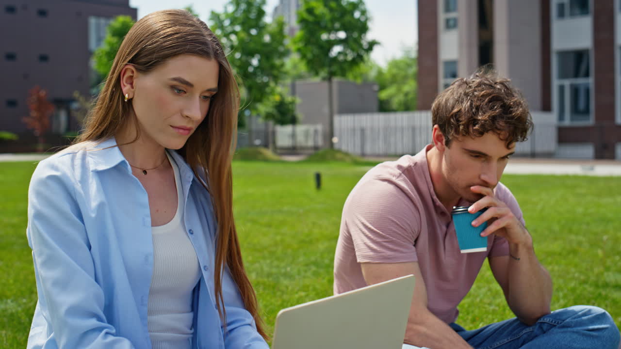 Two employees working park using laptops at grass closeup. Couple freelancers