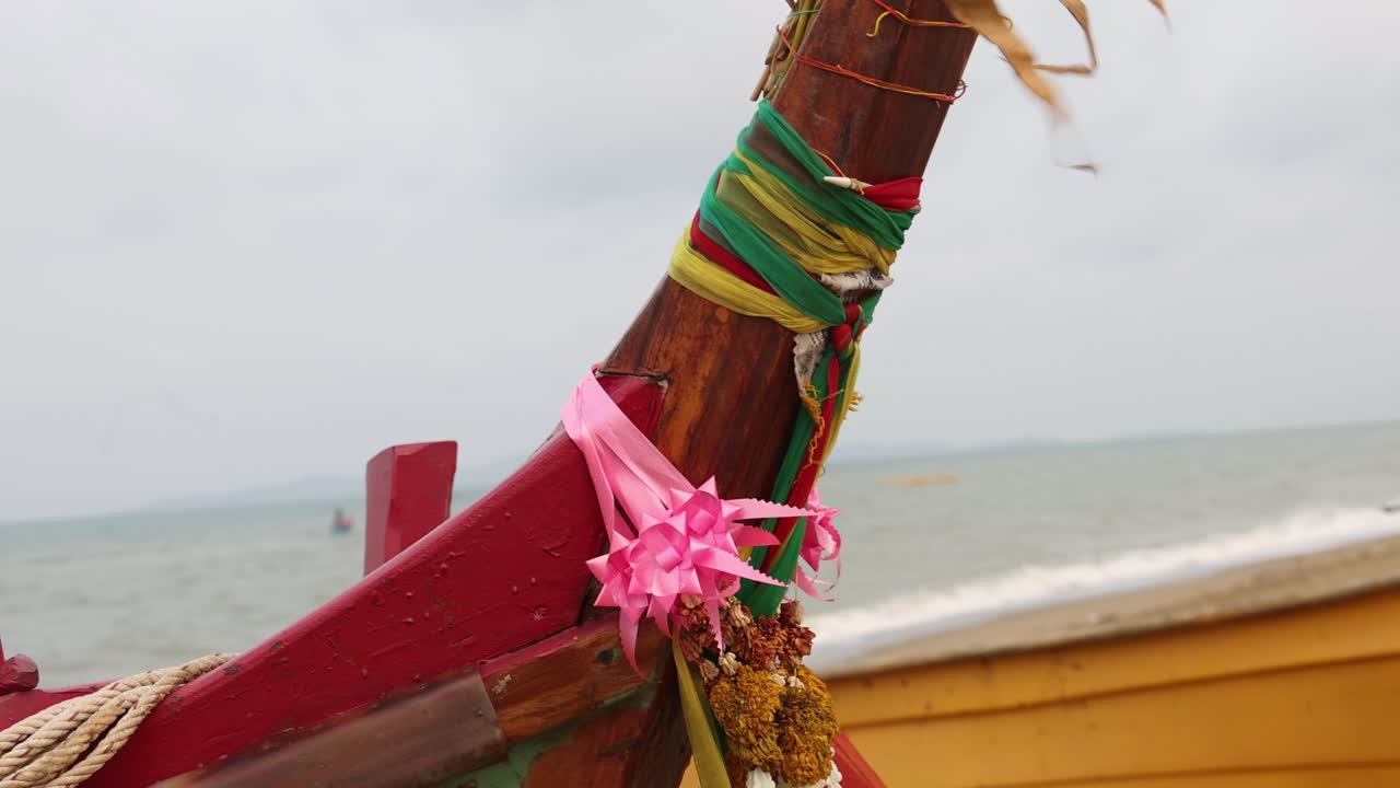 cintas coloridas y flores en la proa de un barco de pesca de madera tradicional en tailandia