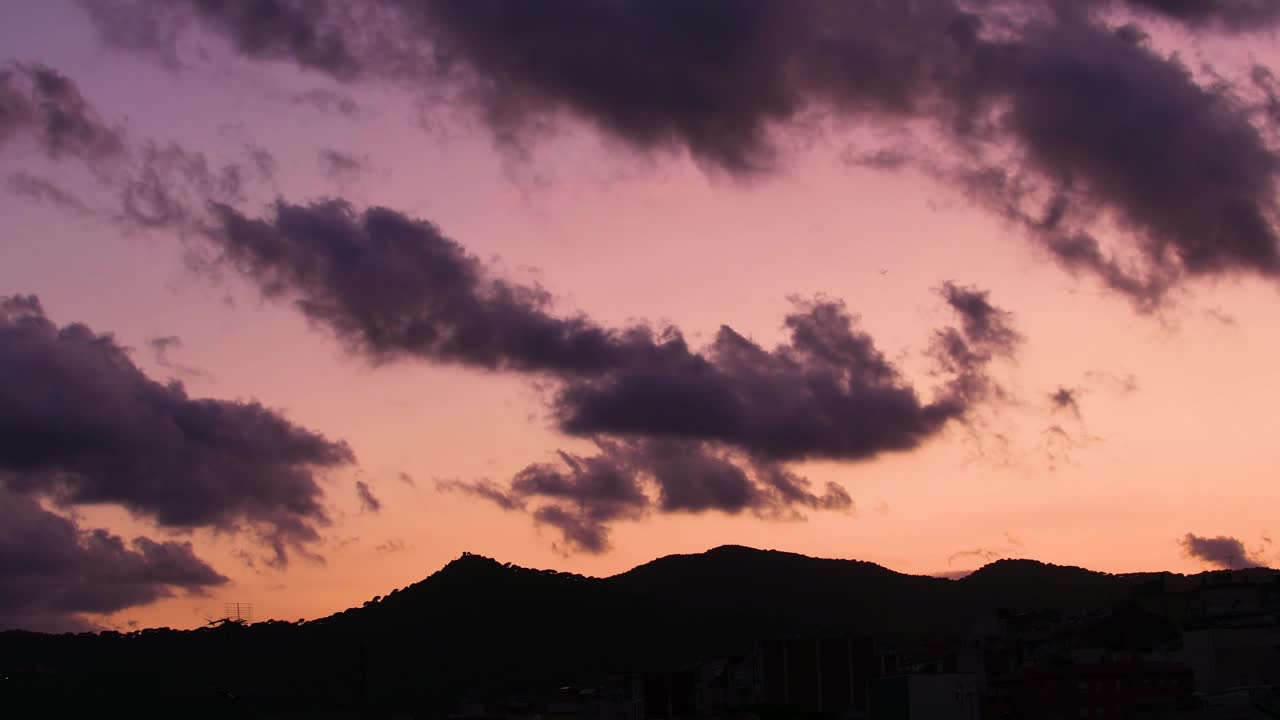 도시 산 너머로 일몰에 움직이는 구름