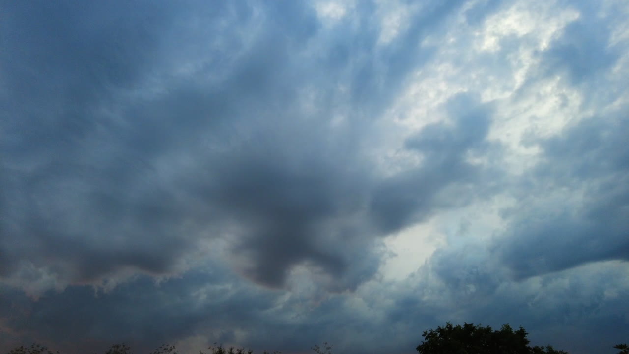 큰 회색 하늘에서 소용돌이치는 극적이고 어두운 폭풍 구름의 시간 경과