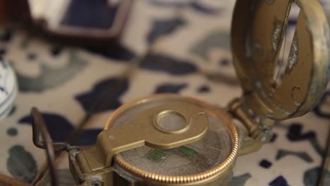 Old-magnetic-compass-close-up-with-a-pan-movement-in-antique-living-room
