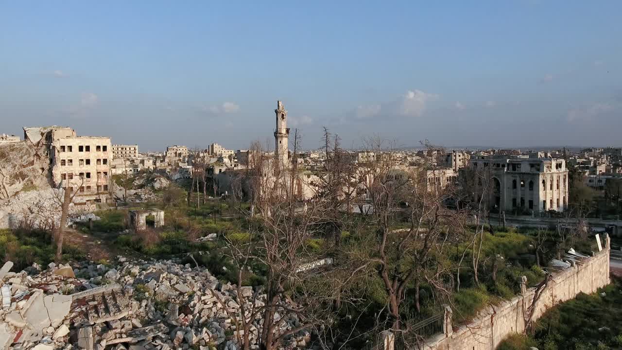 Vista panoramica sui tetti devastati degli edifici nelle strade di Aleppo, sotto un tramonto arancione. Rovine della città di Aleppo dopo la guerra civile in Siria