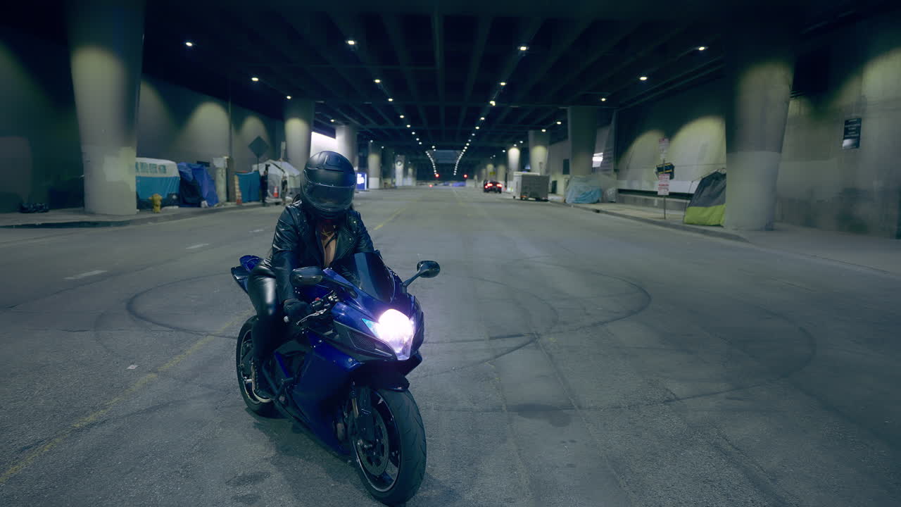 캘리포니아 로스앤젤레스의 지하 도로에서 한 여성이 오토바이에 앉아 있습니다.