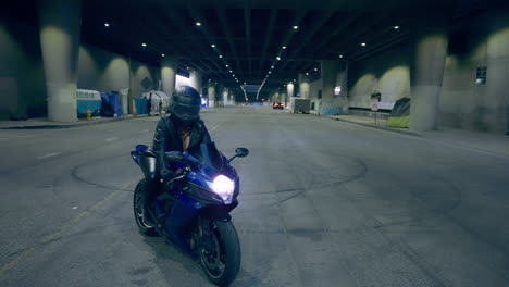 a woman sits on her motorcycle on an underground street in los angeles, ca