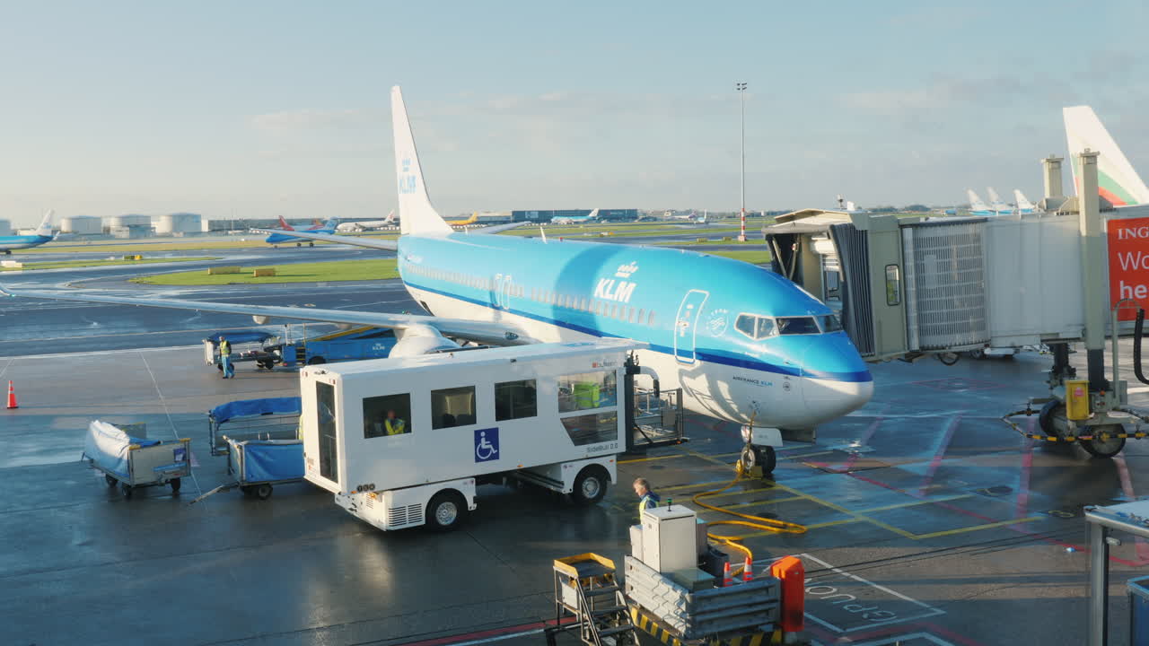 klm 여객기가 공항 터미널에 도착합니다. 아코디언 게이트가 항공기 도어 준비에 합류합니다.