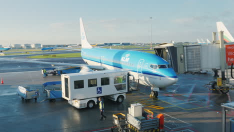 la línea aérea de klm llega a la terminal del aeropuerto la puerta de acordeón se une a la puerta del avión prepari