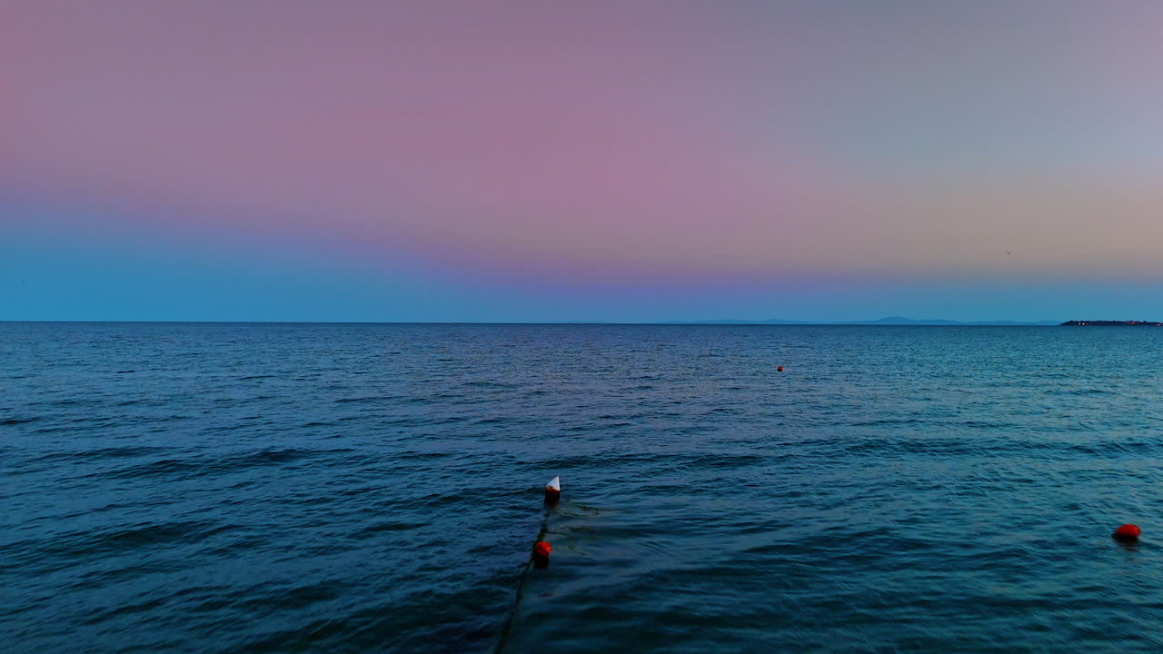 Quickly moving over the blue waterscape at sunset. Beautiful pink blue sky with no clouds at backdrop