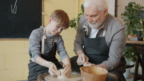 grandfather and grandson learning pottery together