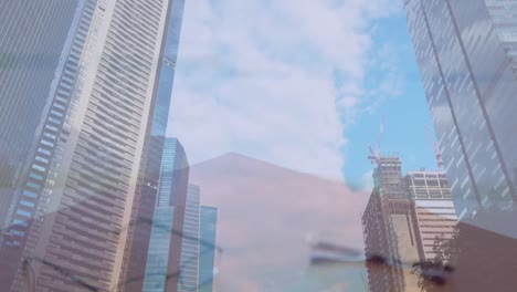 composite video of mid section of businessman and businesswoman shaking hands against tall buildings