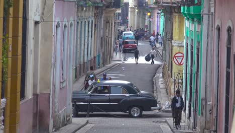 old cars are parked along a narrow street in the old city of havana cuba