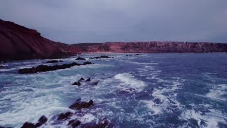 coastal scene at dusk/dawn with red rocks