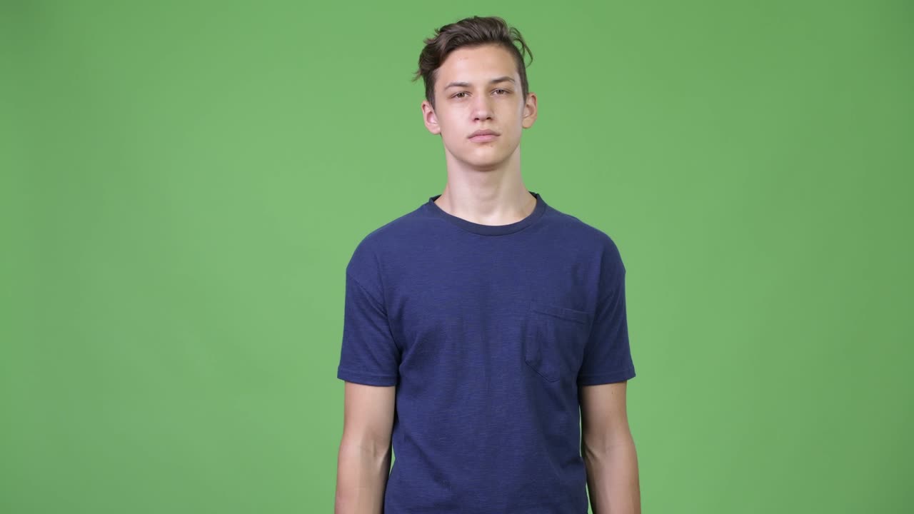 Young handsome teenage boy with finger on lips