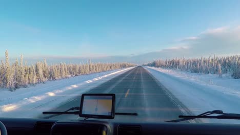 pov shot driving on a arctic road, surrounded by polar forest, gps on, at golden hour, in alaska, united states