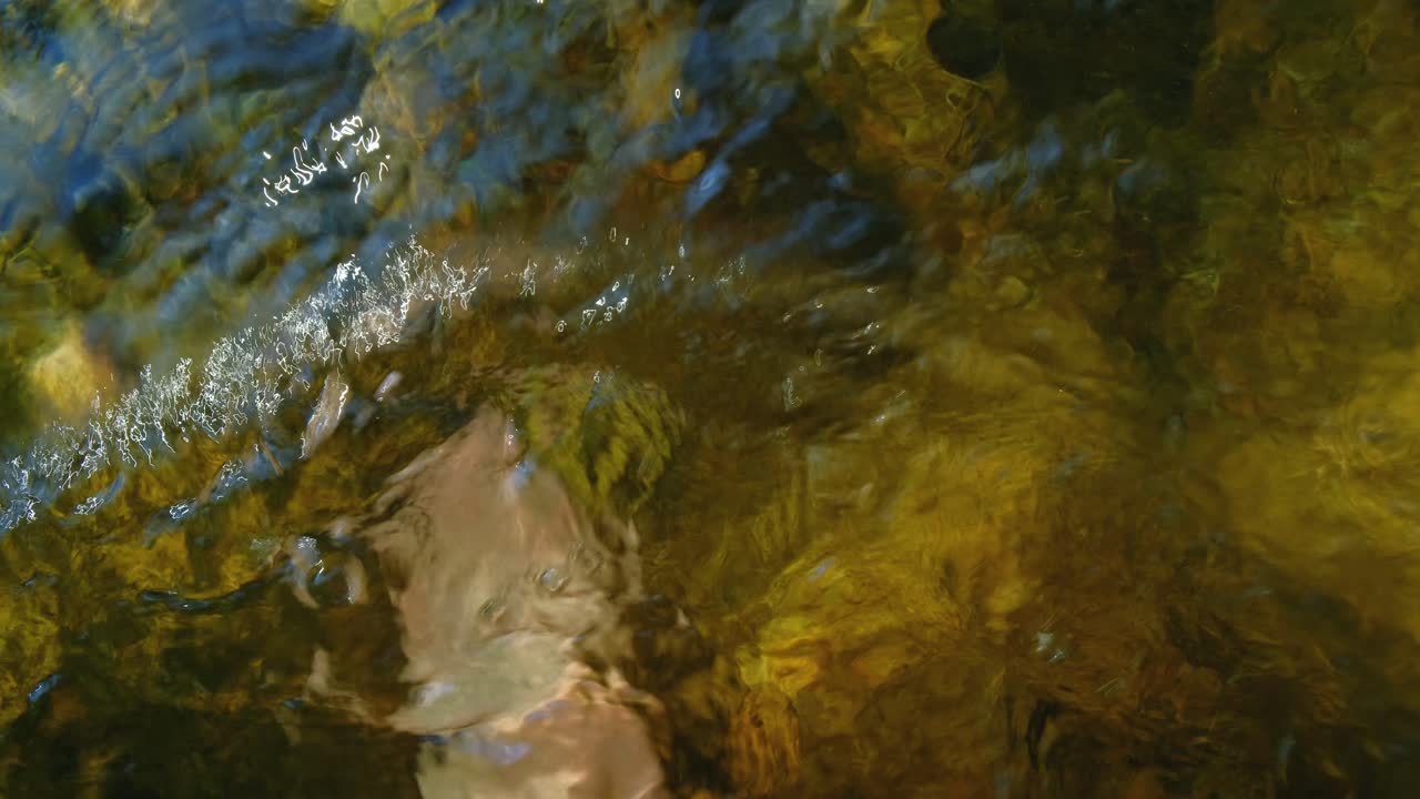Primo piano di piedi di uomo che camminano sott'acqua in un ruscello 4K