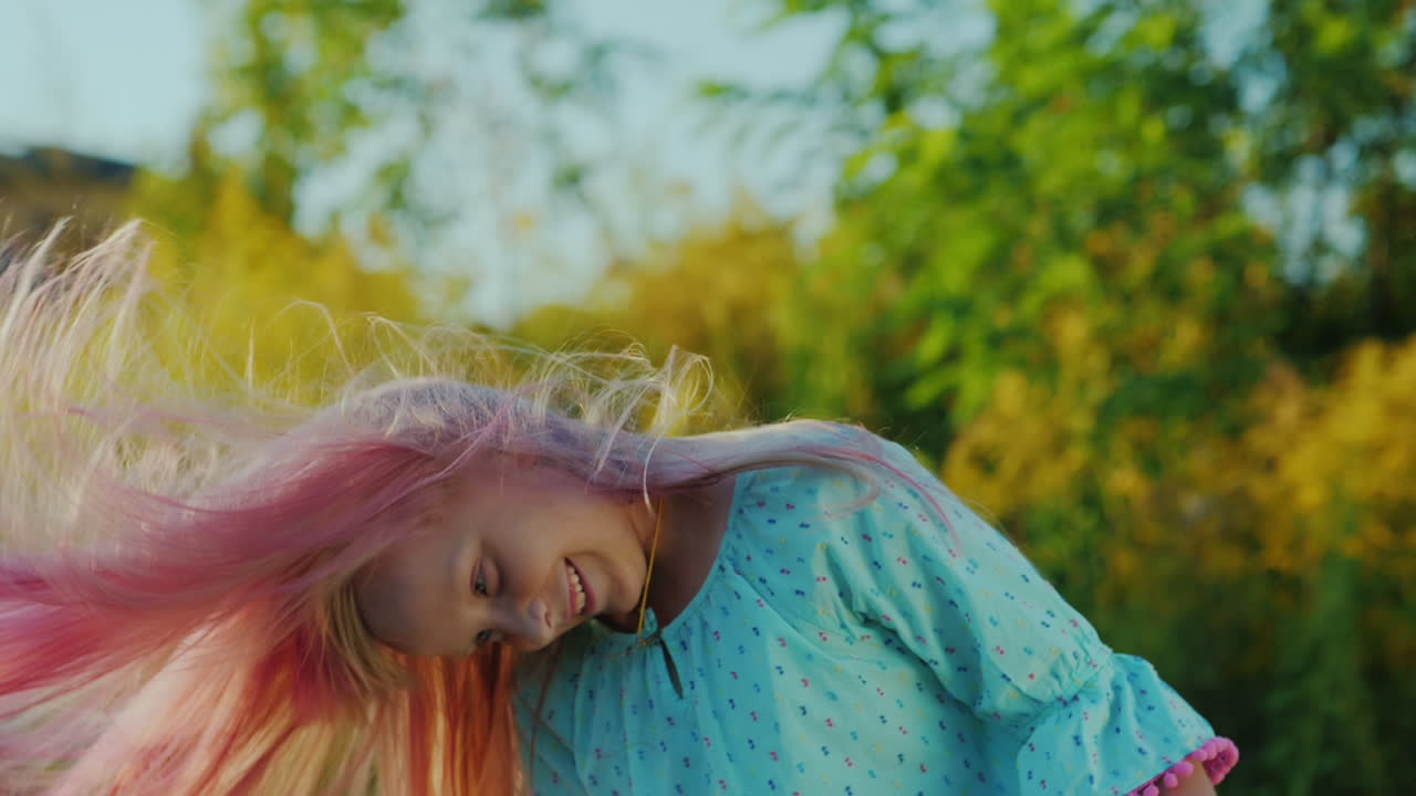 niña jugando con su cabello agitando su cabeza regocijándose en la vida