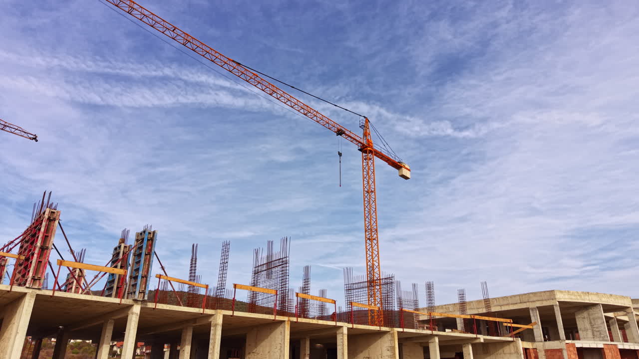 Building progress on a sunny day with cranes towering over the construction site