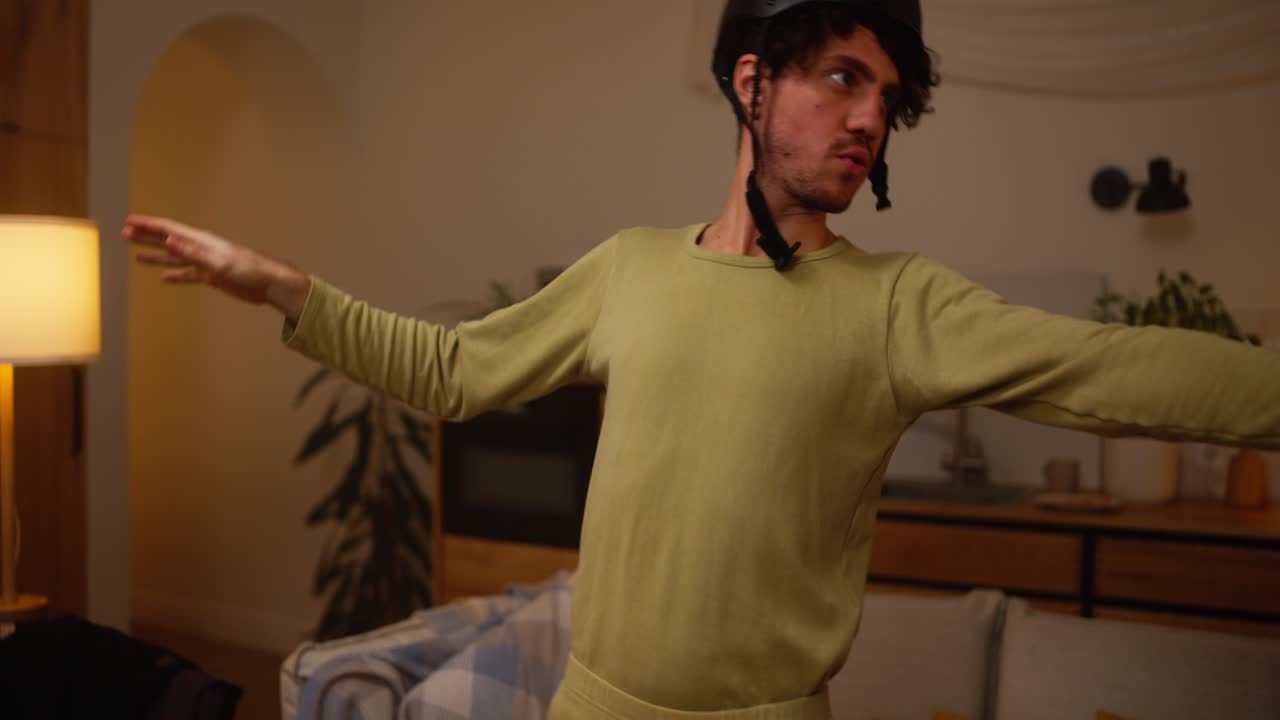 Man wearing a helmet in a funny pose at home