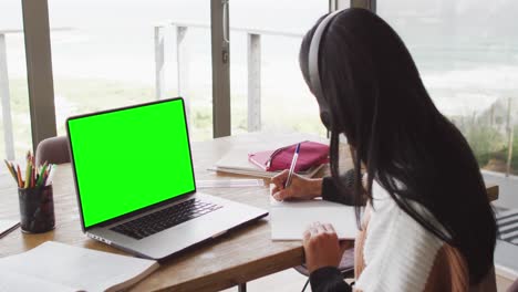 Animation-of-middle-eastern-girl-in-headphones-having-online-lessons-on-laptop-with-copy-space