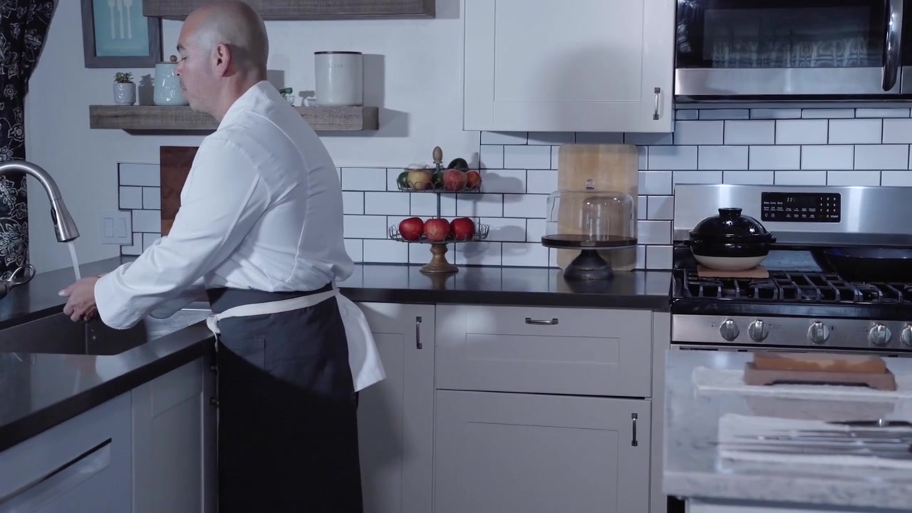 Chef entra na cozinha e lava as mãos em um close-up, plano que acompanha a ação. Destaca a higiene e preparação na cozinha, perfeito para conteúdo culinário ou de segurança alimentar.