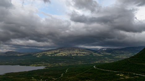 dark storm clouds moving over dovrefjell mountain range and european route e6 thoroughfare in norway