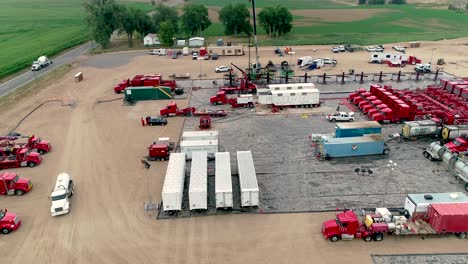 aerial view of a large oil and gas fracking operation site with heavy machinery and trucks