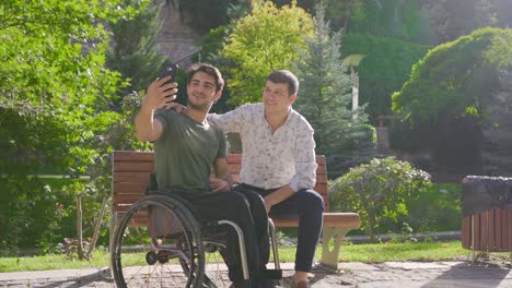 disabled man and friend talking on video phone.