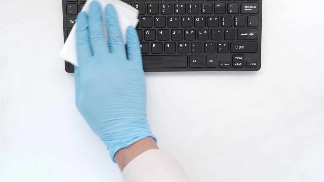 limpieza de un teclado con guantes