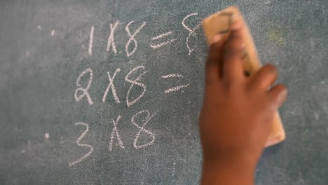 niño de escuela polvo pizarra en el aula en la escuela 4k