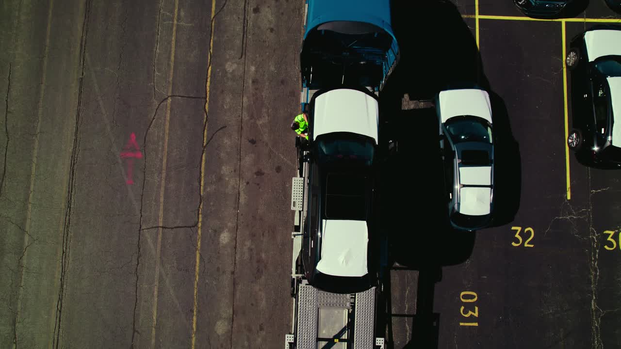 Aerial top view over a car carrier trailer, car hauler truck, loading cars