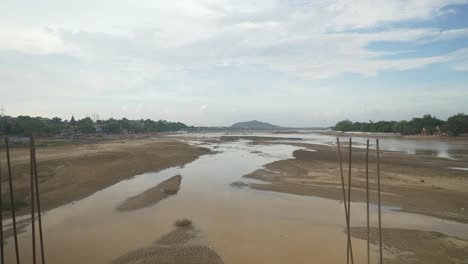 Panoramic-view-of-dry-riverbed-with-leftover-water-in-summer-heat-weather,-Bodhgaya,-Bihar,-India