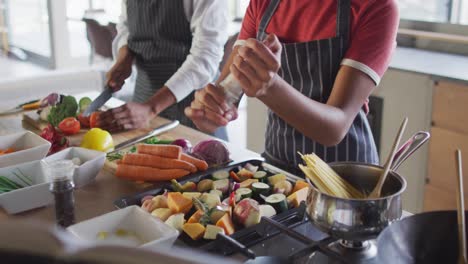 Video-of-happy-diverse-female-friends-cutting-vegetables-and-preparing-meal