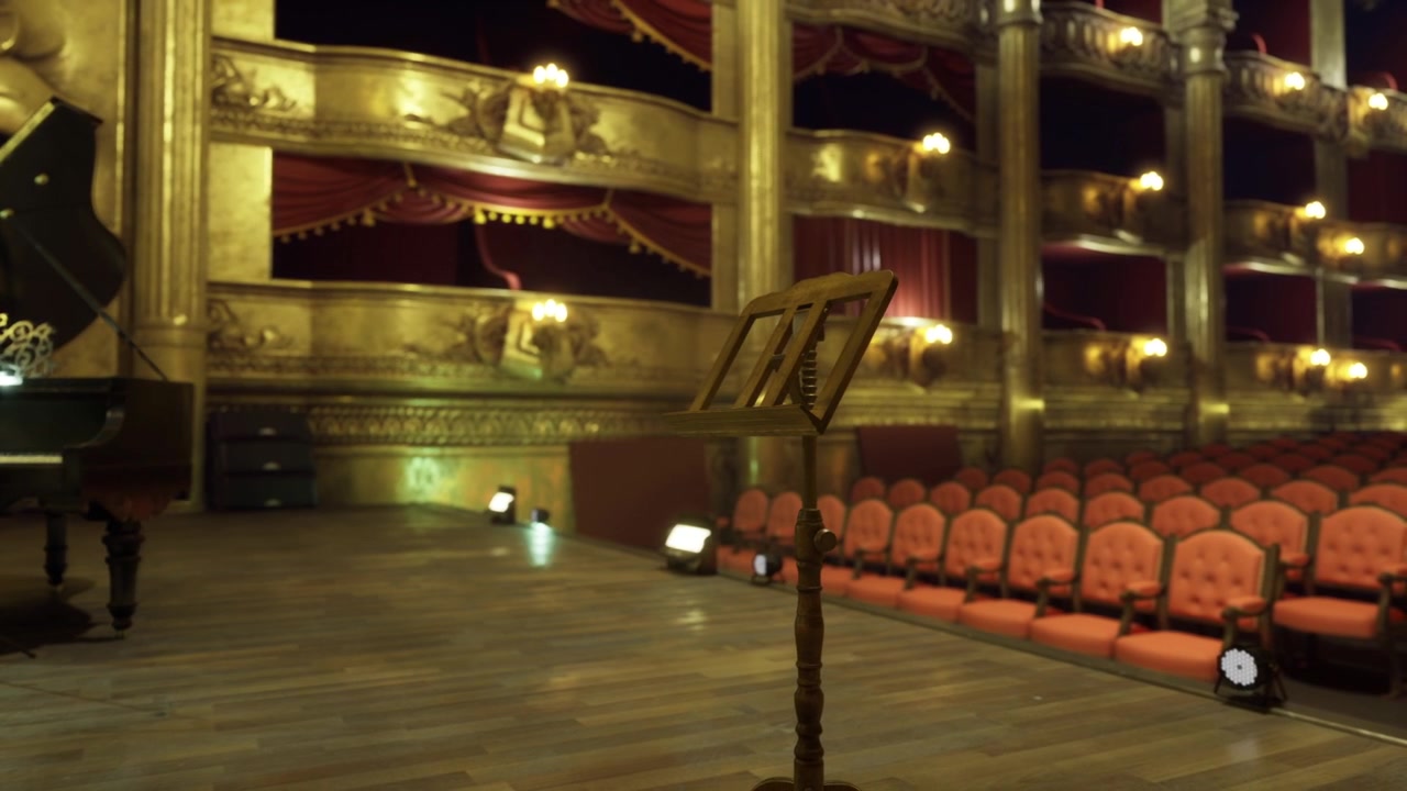 Ampia prospettiva di un teatro che rivela posti a sedere e balconate vuoti.