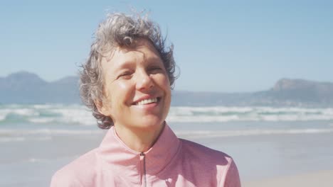 Senior-woman-smiling-and-looking-at-camera-on-the-beach