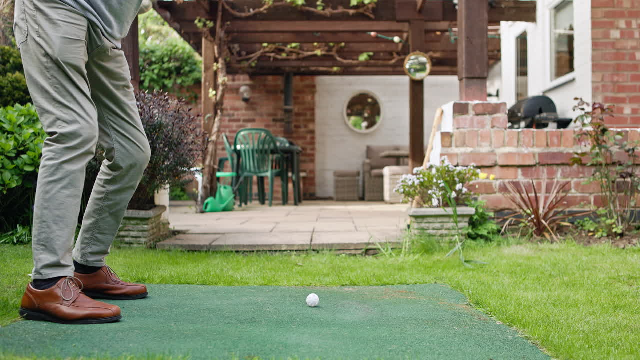 Man playing golf in backyard