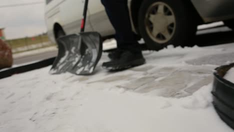 man shovels part of his driveway after a snowfall