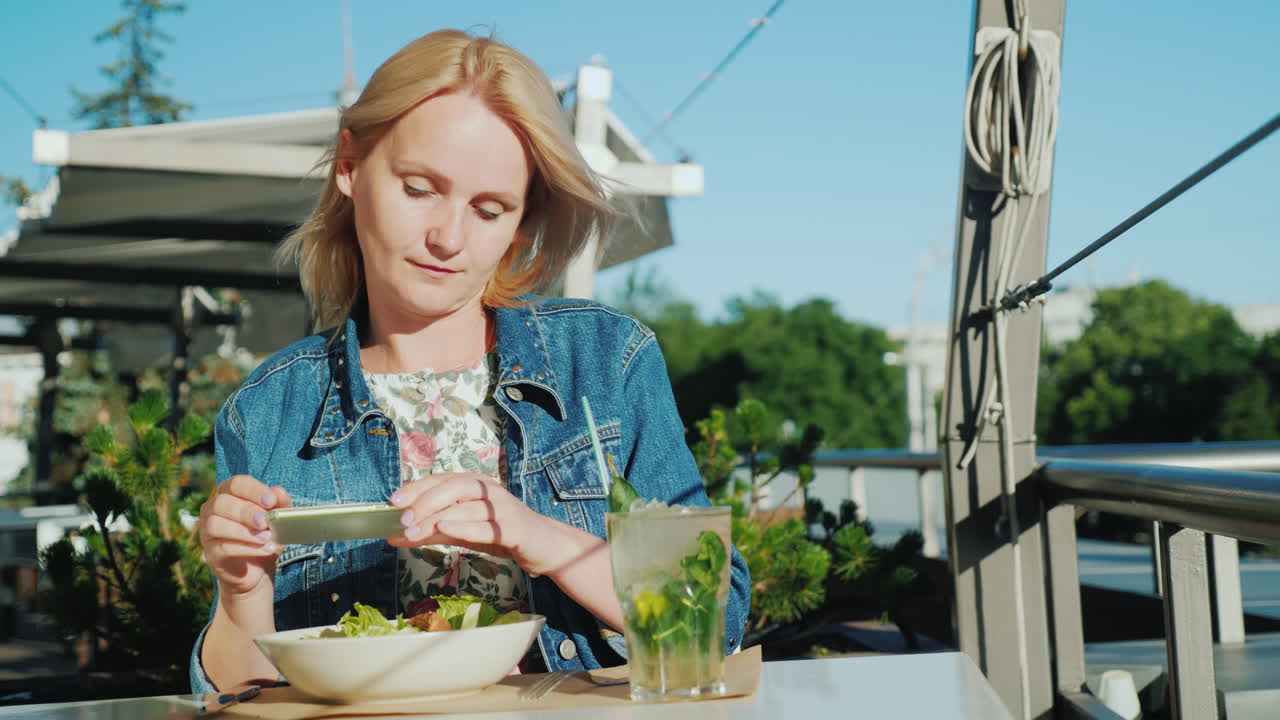 молодая женщина фотографирует красивые блюда в кафе хороший отдых на летней веранде и лето