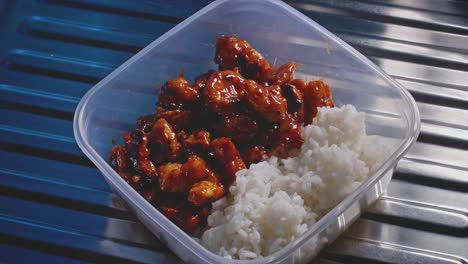 pollo agridulce con arroz enfocándose, comida casera saludable en un tupper